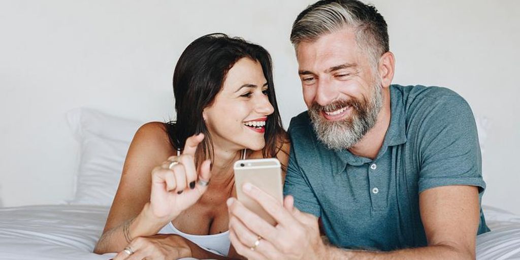 happy couple using dating app on smartphone